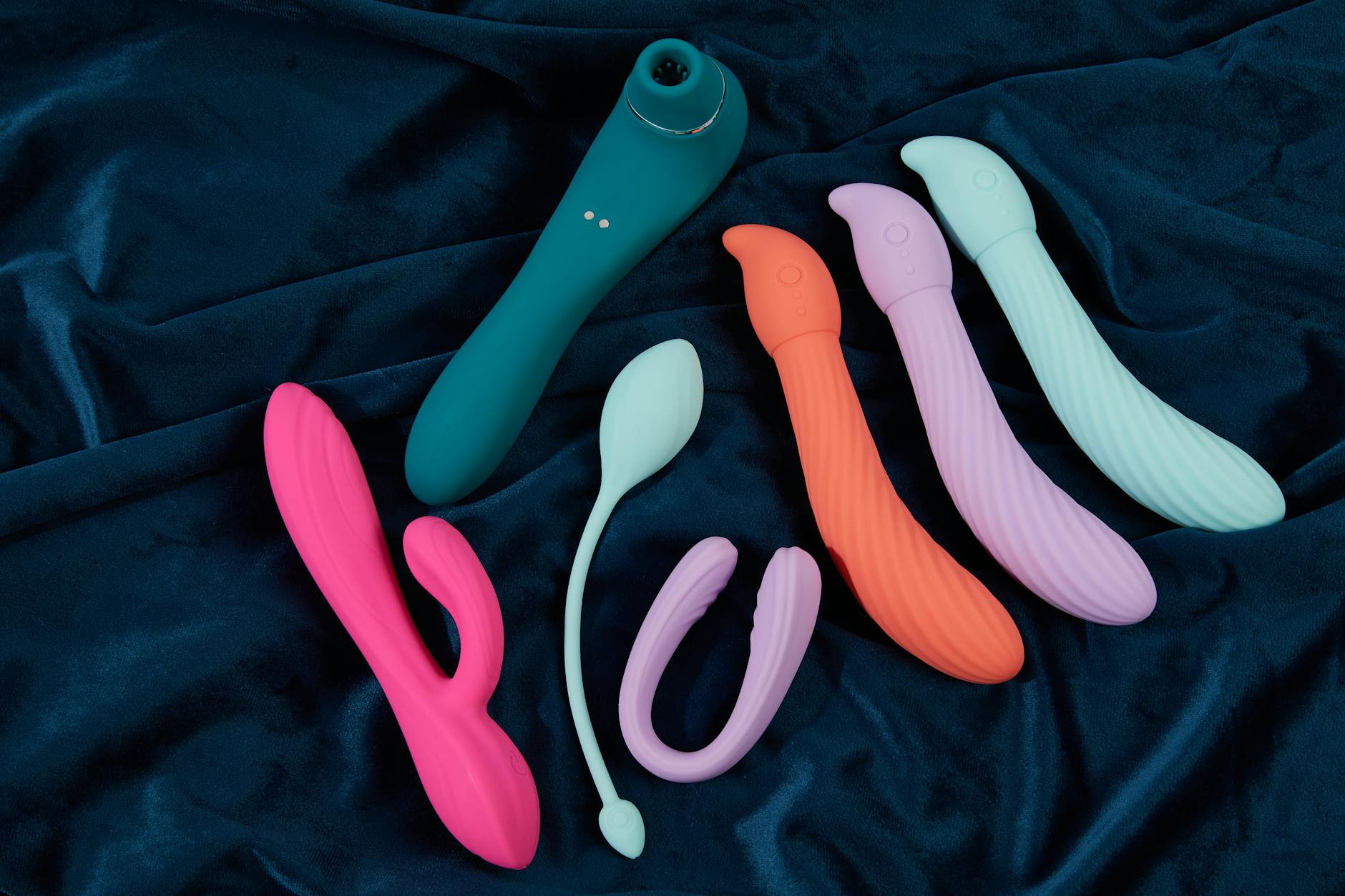 Pink vibrator on purple background with romantic candles and hearts