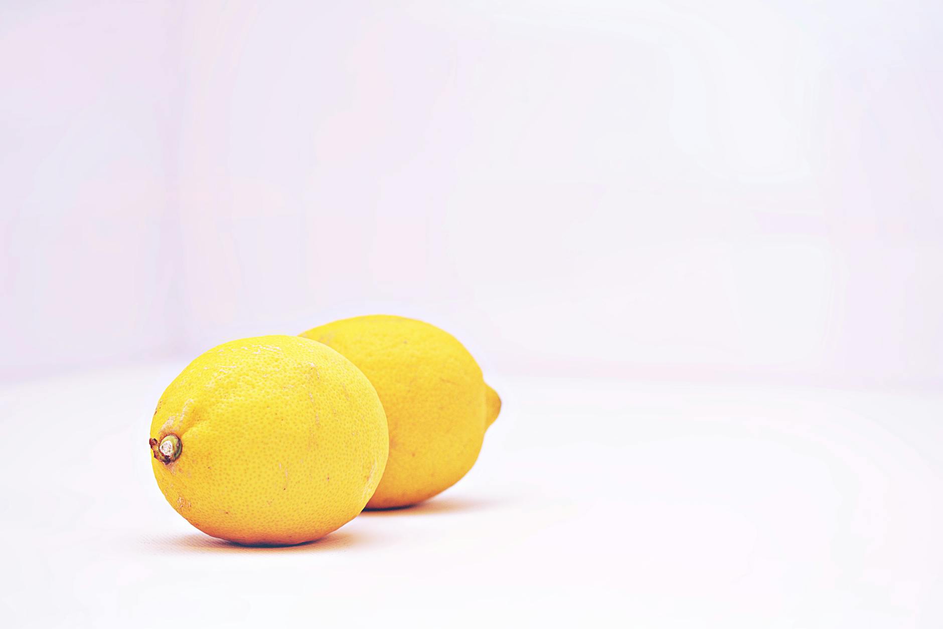 Fresh lemons on white background, symbolizing the citrus-shaped design of lemon clitoral vibrators