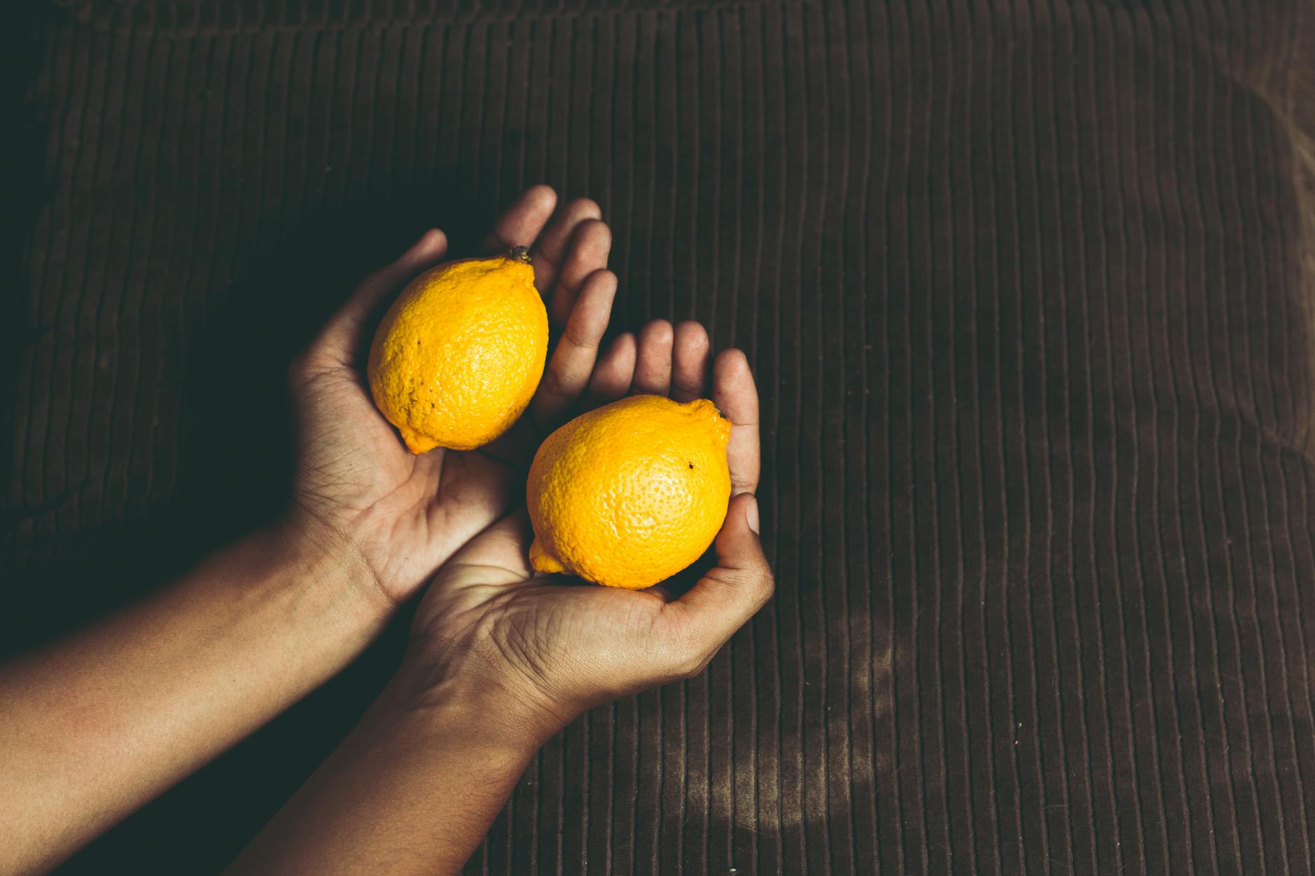 Two hands cupping fresh lemons symbolizing renewal and reconnection with pleasure
