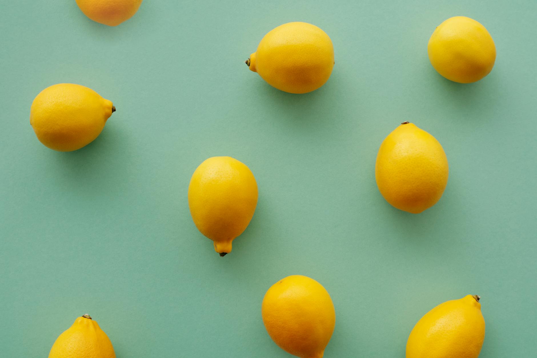 Fresh yellow lemons on a pastel green background, symbolizing clarity and fresh starts