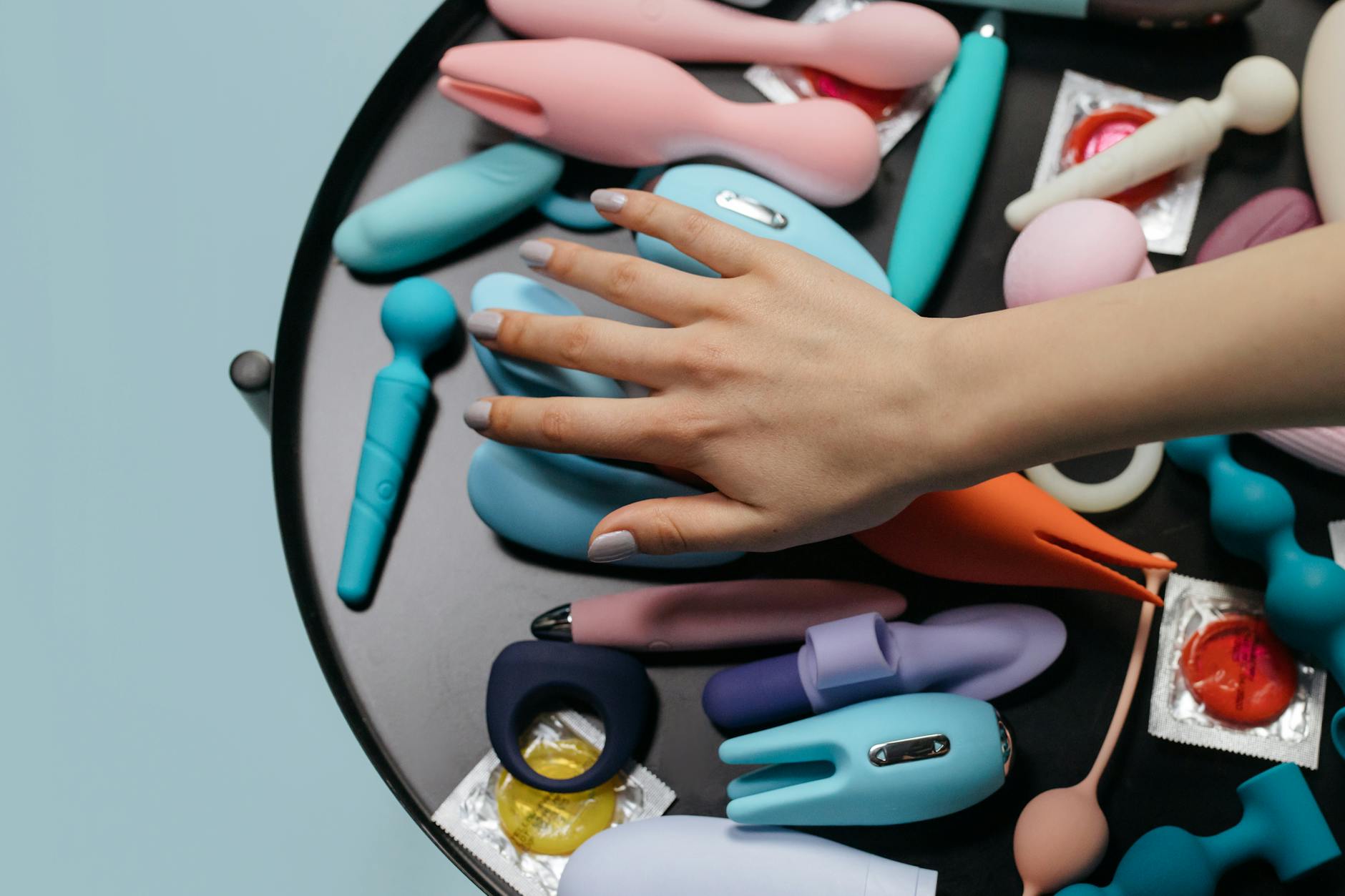 Vibrant arrangement of various colorful sex toys on a bright yellow surface, including lemon-shaped designs